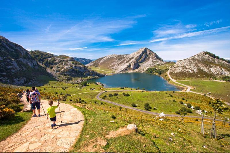 Excursionistas en lagos de montaña bajo cielo azul.