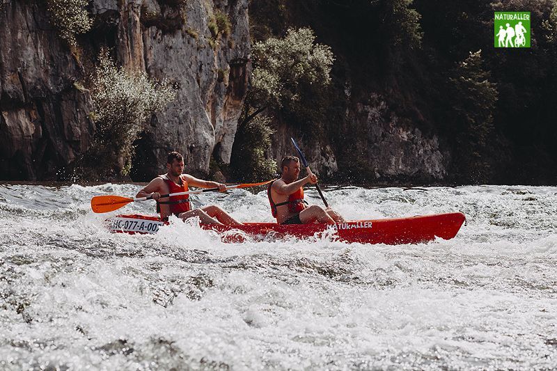 Personas remando en un río con kayak