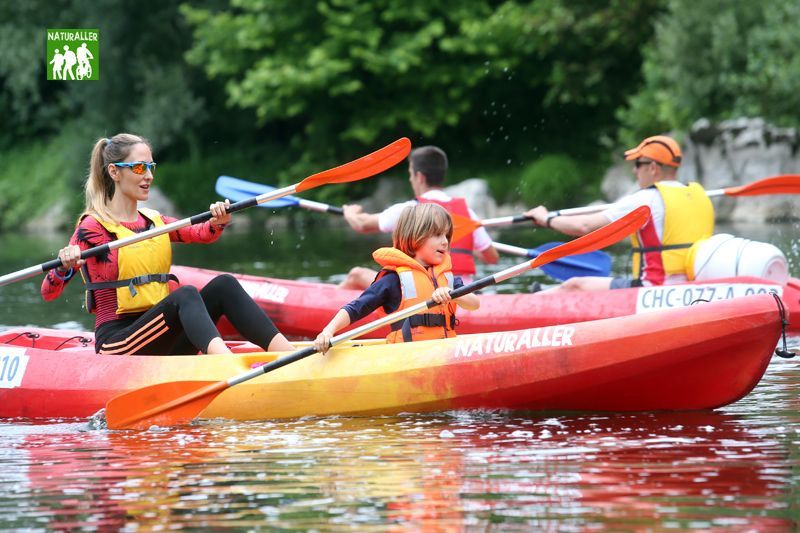 Familia navegando en kayak río verde